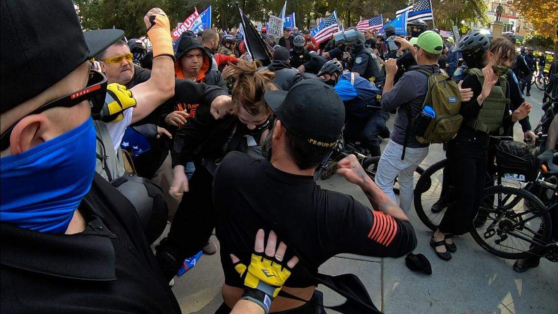 Members of the Proud Boys brawl with counter-protesters at Cesar Chavez Plaza in Sacramento after a Trump rally on Saturday, Nov. 21, 2020. Police tried to keep the two groups separated with barricades as they rallied near the Capitol. But the Trump group managed to break through and marched to where they were confronted by counter protesters