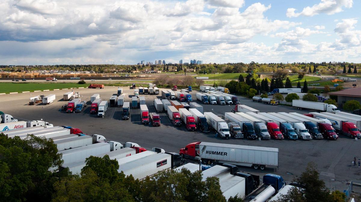 Big rigs fill the tractor-trailer lot behind the Sacramento 49er Travel Plaza in March 2020. Trucks in California will have to undergo smog-checks starting in 2023.