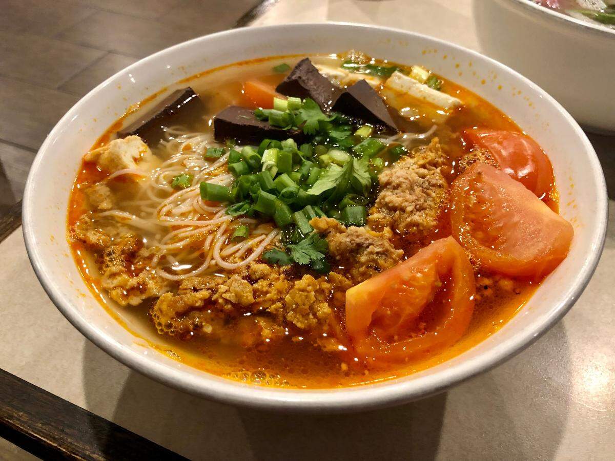 Phở Le serves a Vietnamese crab soup called bún riêu. Coagulated pork blood, seen in the back, is optional.