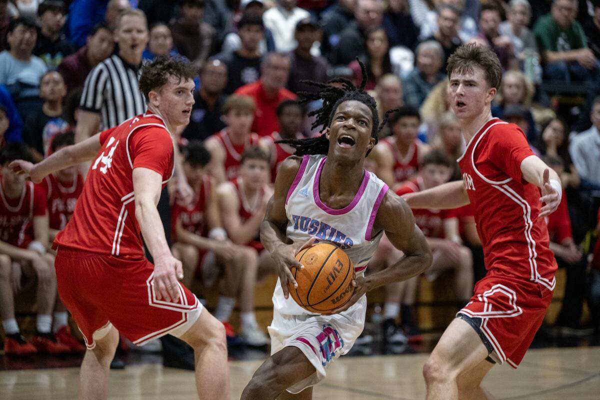 The Sheldon Huskies’ Baron Sabir drives to the basket past the Folsom Bulldogs’ Alec Day (14) and Jack Shull in the second half of a CIF Sac-Joaquin Section Division I semifinal game Tuesday in Vineyard.