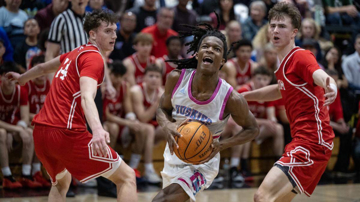 The Sheldon Huskies’ Baron Sabir drives to the basket past the Folsom Bulldogs' Alec Day (14) and Jack Shull in the second half of a CIF Sac-Joaquin Section Division I semifinal game on Feb. 24 in Vineyard.