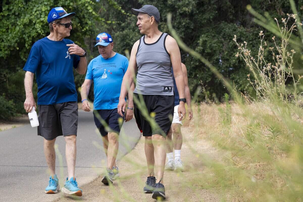 Sacramento FrontRunners, from left, James Evans-Brown, Jeffery Lore and Saul Arcos walk along the American River Parkway in Sacramento on Saturday.