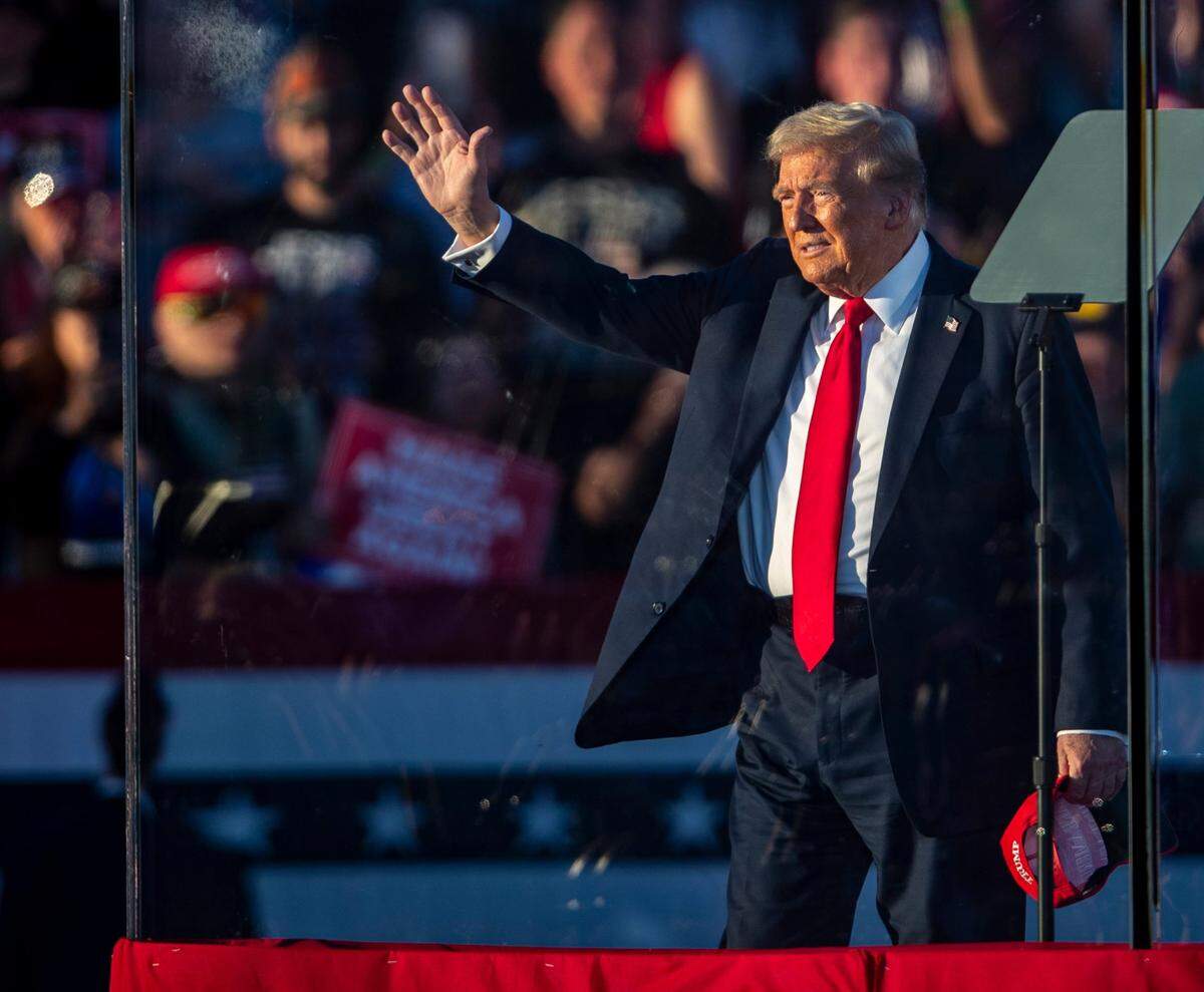 Former President Donald Trump waves to supporters as he arrives on stage during a campaign rally near Coachella, Calif., on Saturday. Local law enforcement said they arrested a man attempting to enter the rally with multiple passports and ID cards with different identities, weapons and a vehicle with fake license plates.