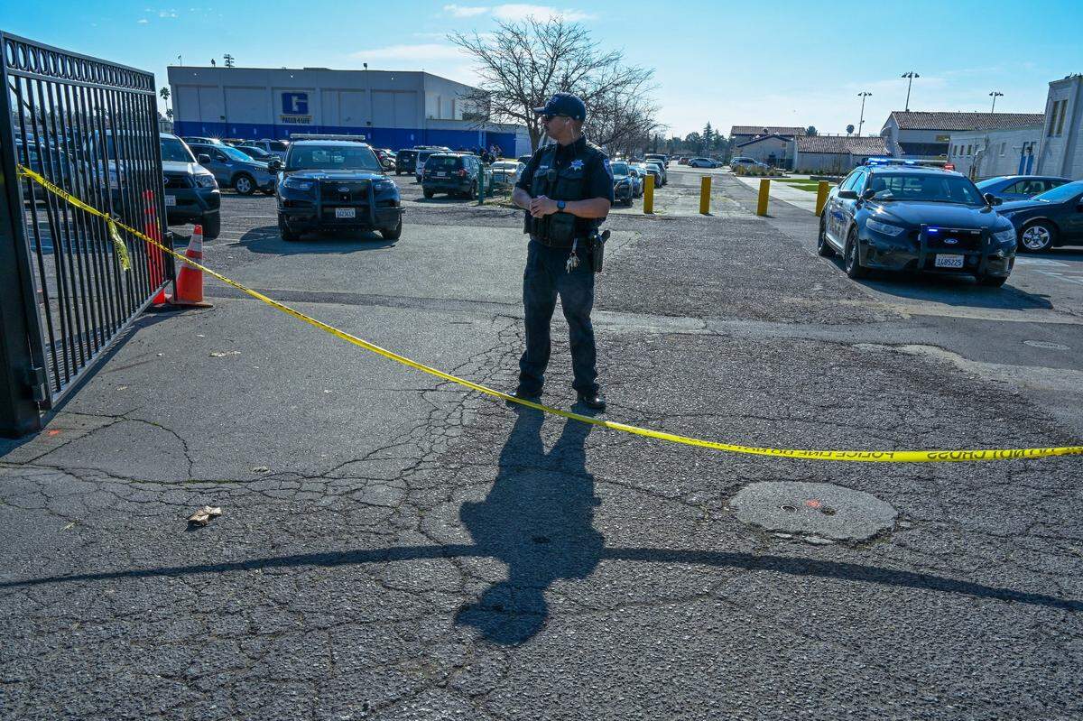 A Sacramento Police officer guards the gate to Grant High School as officers investigate the scene where a student was shot in the arm at Grant High School on Tuesday.