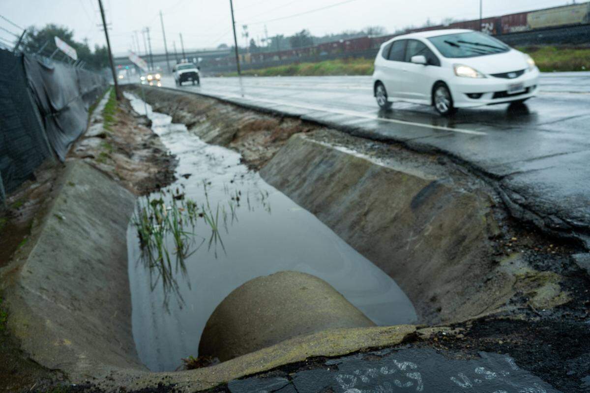 Cars drive along Roseville Road in Sacramento earlier this month near the entrance of the city’s homeless shelter location.