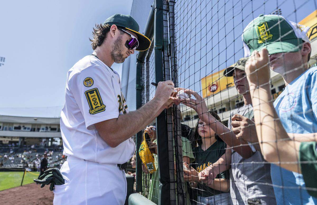 Athletics shortstop Jacob Wilson (5) signs autographs for young fans before a game at Sutter Health Park on April 9. Wilson became the first rookie shortstop in MLB history to be elected by fans to start an All-Star Game.