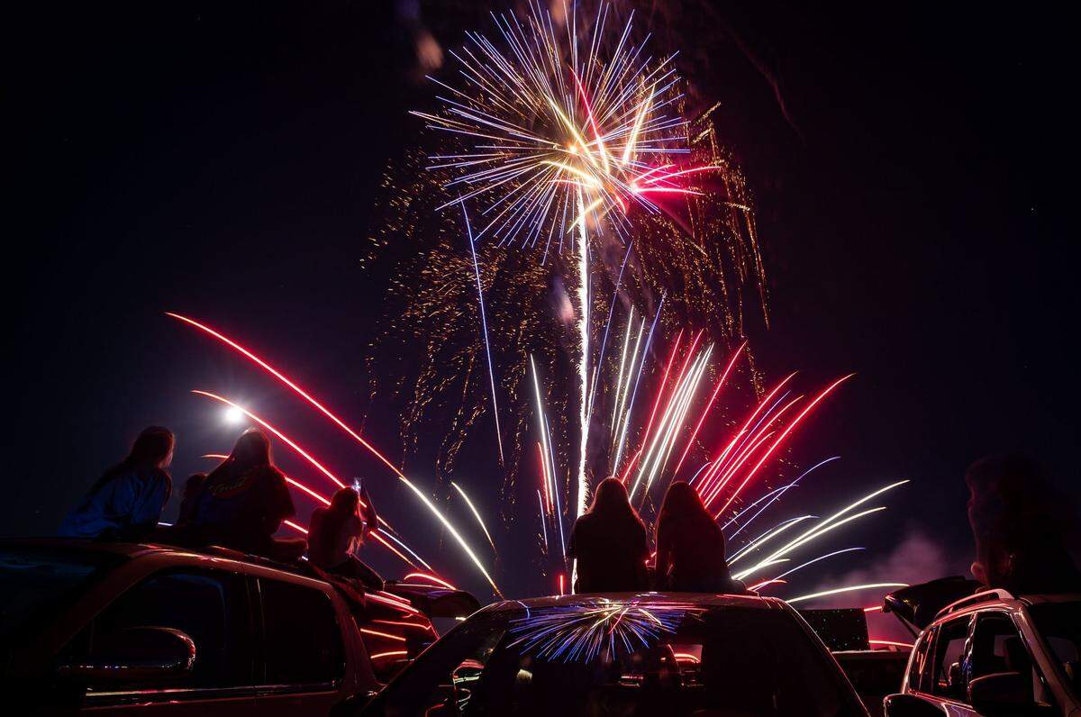 The Star Spangled Drive In Independence Day fireworks show fires off in the sky above 14-year olds Ava Borchers, center, of Roseville, and Taylor Daggett, of Rocklin, on Friday, July 3, 2020, south of Highway 50 in the planned Folsom Ranch community. Tickets were sold out in advance, limiting attendance for the locally-sponsored event, which was advertised as a socially-distanced and safe evening celebrating the community and nation.