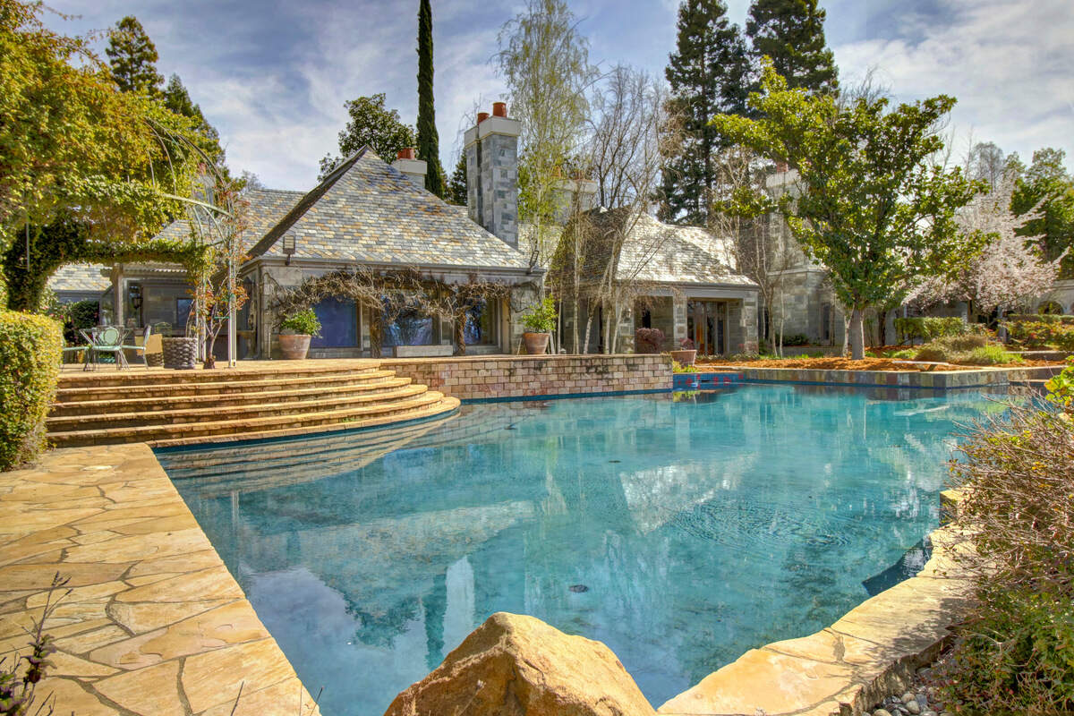 The lagoon-style pool highlights an extraordinary backyard of gardens and pathways.