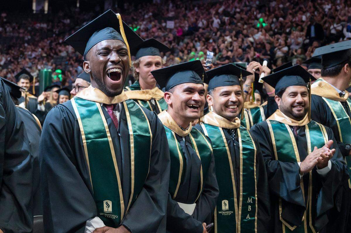Graduates cheer during the Sacramento State College of Business commencement on Friday.