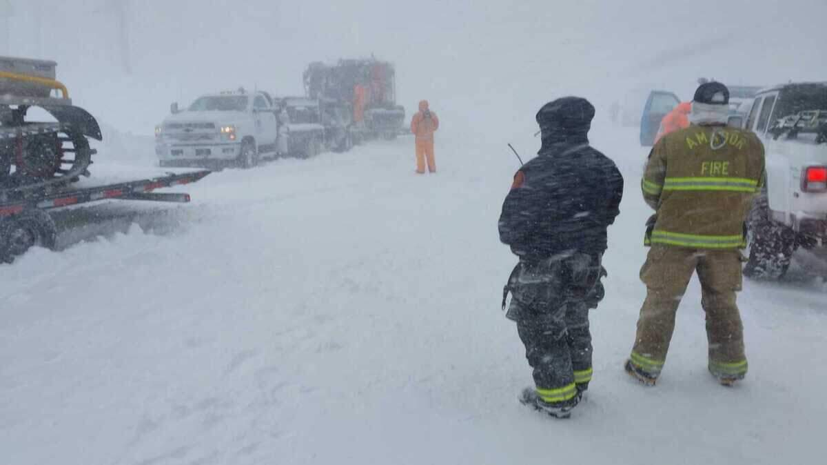Emergency responders stand near rescue vehicles on Mormon Emigrant Trail on Tuesday, Feb. 17, 2026, in El Dorado County, Calif., as snow falls during a major winter storm. Authorities used tracked vehicles to navigate deep snow while searching for two adults reported stranded since Monday afternoon amid dangerous conditions across the Sierra Nevada.