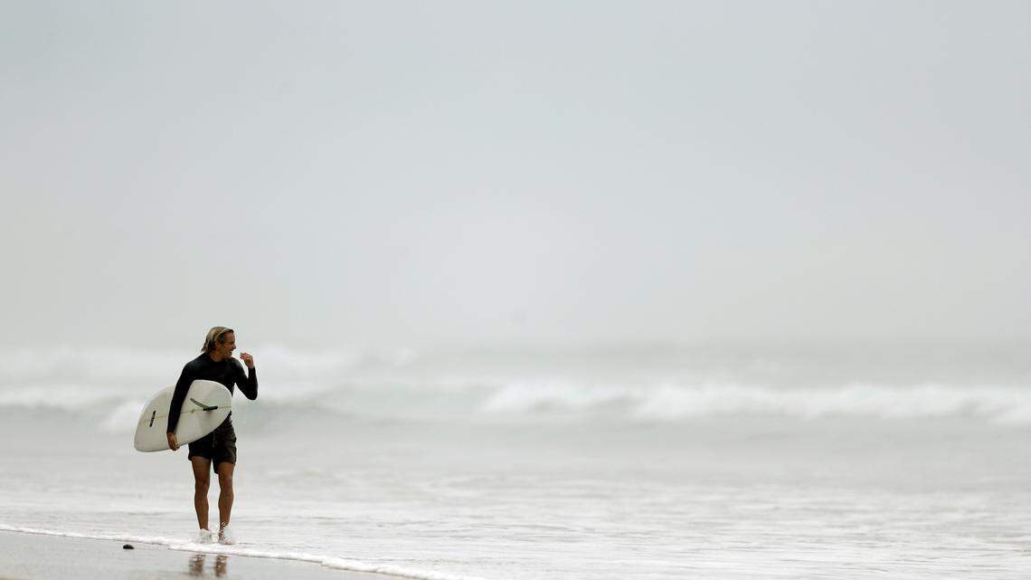 A surfer leaves the water in Southern California in 2018. A collision with a fellow surfer Saturday killed a band tour manager off Rincon Point near Santa Barbara, California, authorities say.