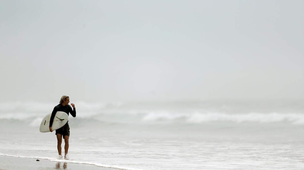 A surfer leaves the water in Southern California in 2018. A collision with a fellow surfer Saturday killed a band tour manager off Rincon Point near Santa Barbara, California, authorities say.