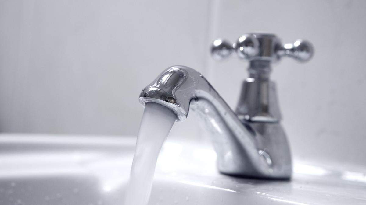 Close up of chrome tap, water running.