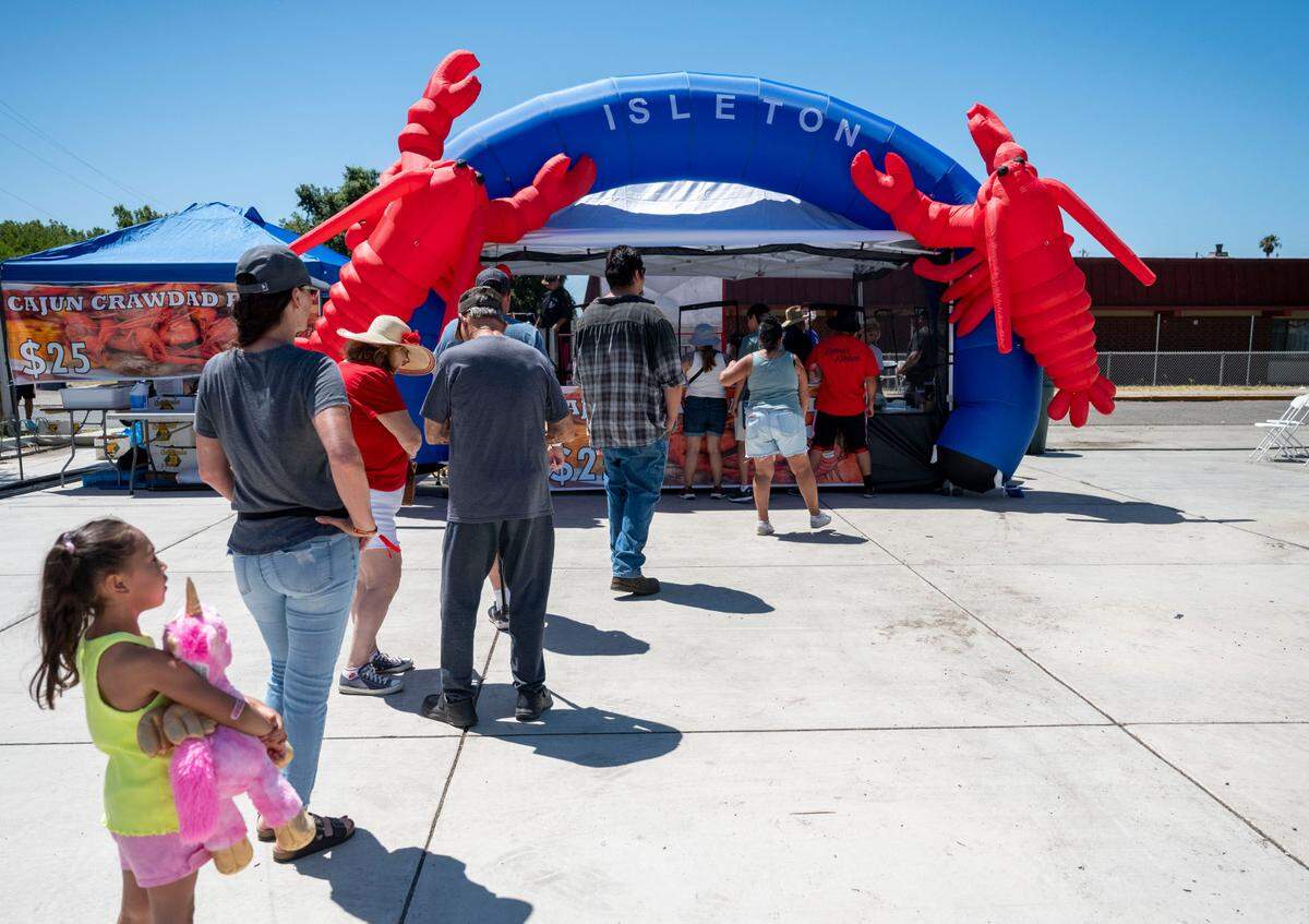 People wait in line to get crawdads from Sharky’s Chicken and Fish at the City of Isleton Crawdad Festival on Sunday.