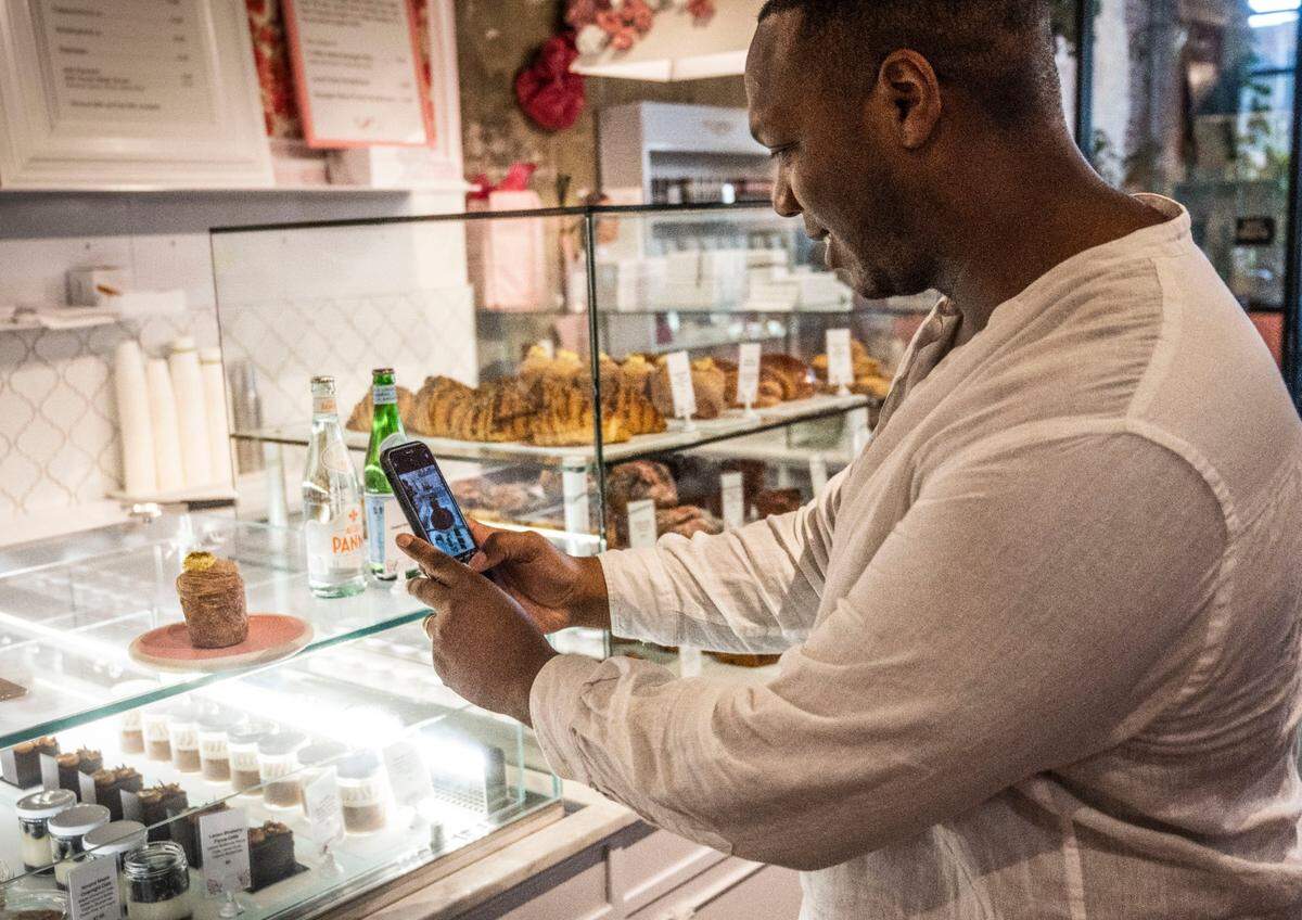 Jared Alwin Crooks, of New York, takes a photo of a Bing Cherry Pistachio Cruffin at Ginger Elizabeth Patisserie on Tuesday. The bakery sells the treat for $6.50.