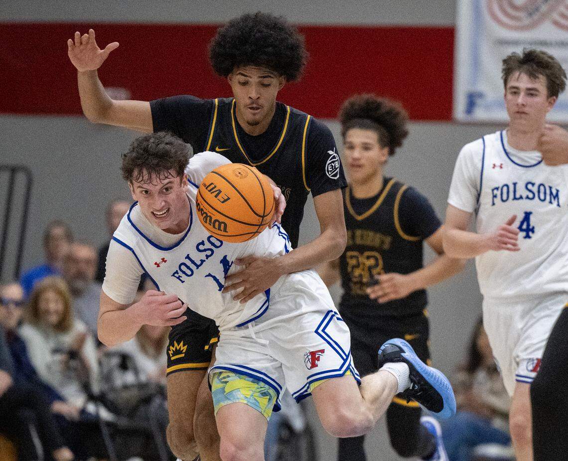 The Kings Academy Knights’ Boss Mhoon defends the Folsom Bulldogs' Alec Day as he dribbles up court in the second half in the CIF Northern California Regional Division I boys basketball championship on Tuesday in Folsom.