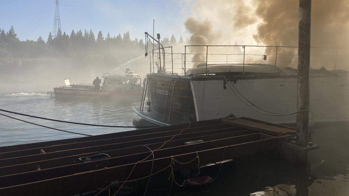 A boat burns near the 2100 block of Garden Highway on June 21, 2022. Fire officials said the boat was likely to sink.
