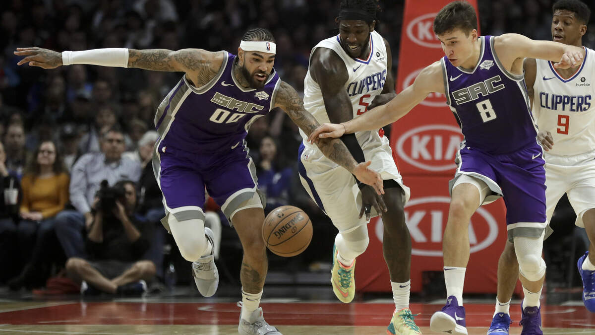 Kings center Willie Cauley-Stein, left, and guard Bogdan Bogdanovic, right, take the ball away from Los Angeles Clippers forward Montrezl Harrell, middle, on Wednesday in Los Angeles.