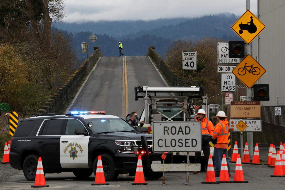 Officials block the Fernbridge in Ferndale, Calif., following an earthquake Tuesday, Dec. 20, 2022. A powerful earthquake that rocked a rural stretch of the Northern California coast has cut off power to thousands of homes and businesses and damaged roads and homes. (Santiago Mejia/San Francisco Chronicle via AP)