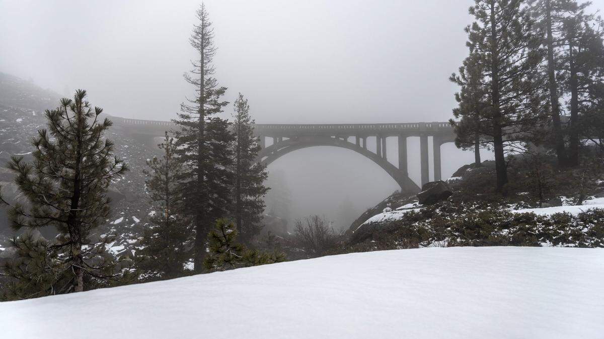 The historic Donner Summit Bridge stands on a foggy Thursday. Also known as the Rainbow Bridge, it carries Old Highway 40 over the Sierra. Heavy snowfall last winter closed the road for much of the season, and damage from rock estimated to weigh up to 12 tons in early June closed it over the summer, causing challenges for local businesses.