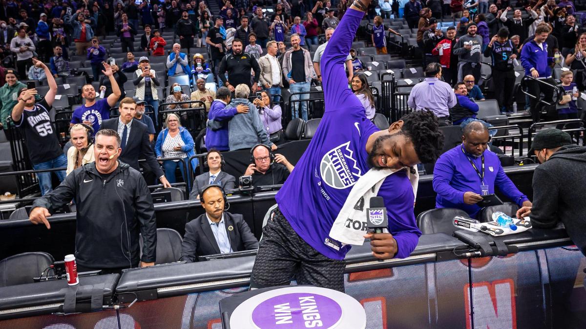 Sacramento Kings center Chimezie Metu raises his hand to swing down on a “button” to light the beam after their 130-112 win over the San Antonio Spurs, as Kings public address announcer Scott Moak cheers at left, at the NBA basketball game Thursday at Golden 1 Center.