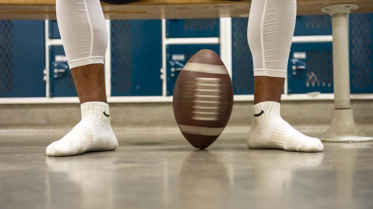 A football spins on its tip as players warm up inside the locker room in 2018.