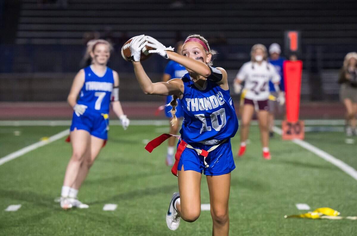Rocklin Thunder wide receiver Abigail Schrader (10) makes a fingertip catch from quarterback Robyn Nguyen to open the second half against the Whitney Wildcats in September 2023.