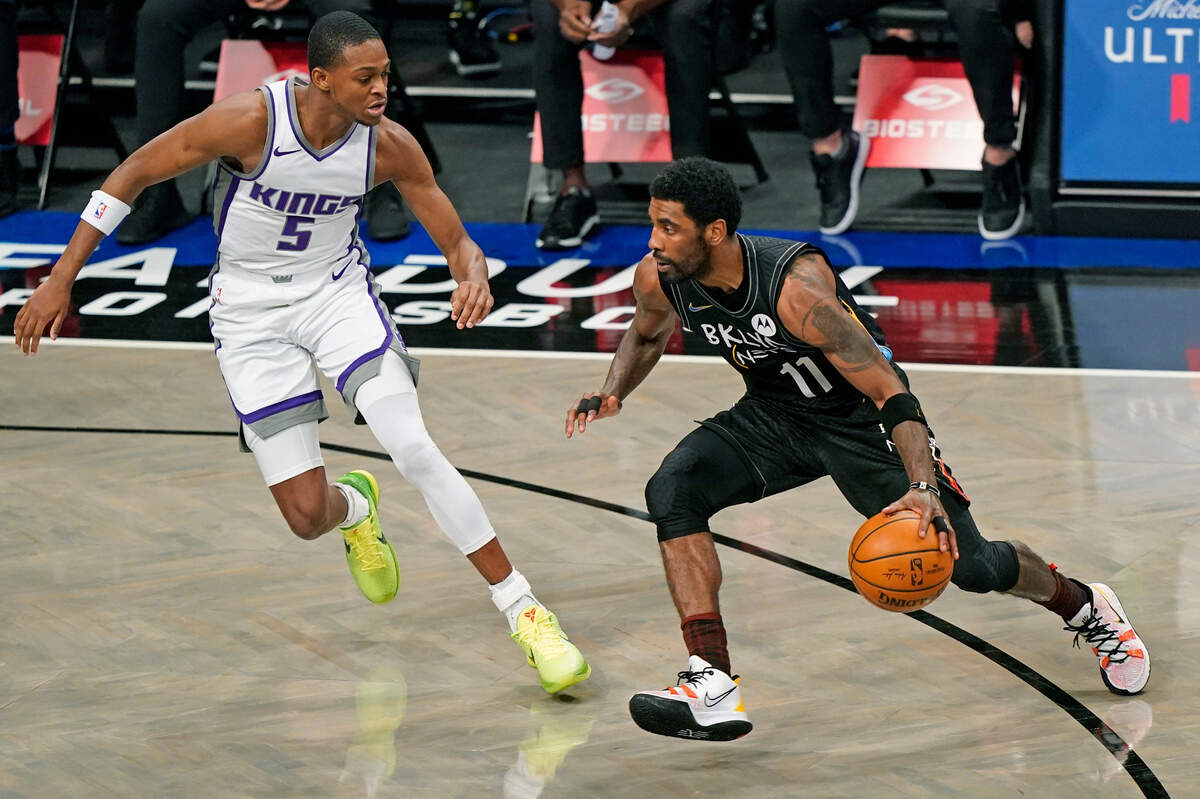 Brooklyn Nets guard Kyrie Irving (11) drives to the basket with Sacramento Kings guard De’Aaron Fox (5) defending during the first quarter of an NBA basketball game, Tuesday, Feb. 23, 2021, in New York. (AP Photo/Kathy Willens)