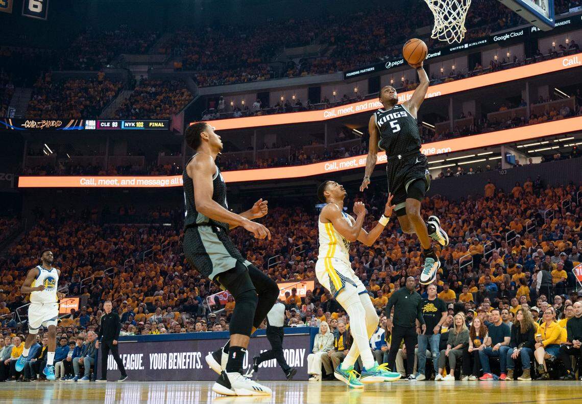 Sacramento Kings guard De’Aaron Fox dunks the ball defended by Golden State Warriors guard Jordan Poole during Game 4 of the first-round NBA playoff series at Chase Center in San Francisco on Sunday.