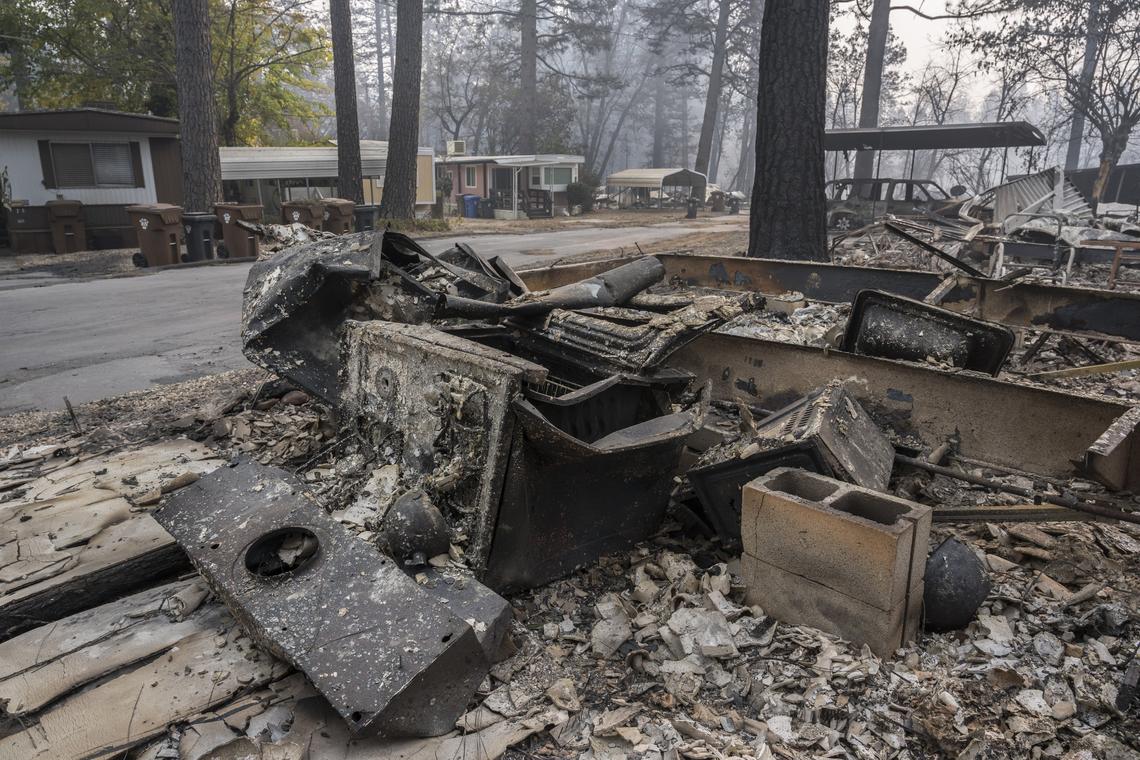 The remnants of a stove and kettle are seen across the street from the only mobile homes that survived the deadly Camp Fire at the Pine Springs Mobile Home Park in Paradise. A plan to open a temporary scrapyard in Chico, for sorting metal and concrete rubble, has been abandoned after neighbors and city leaders protested.