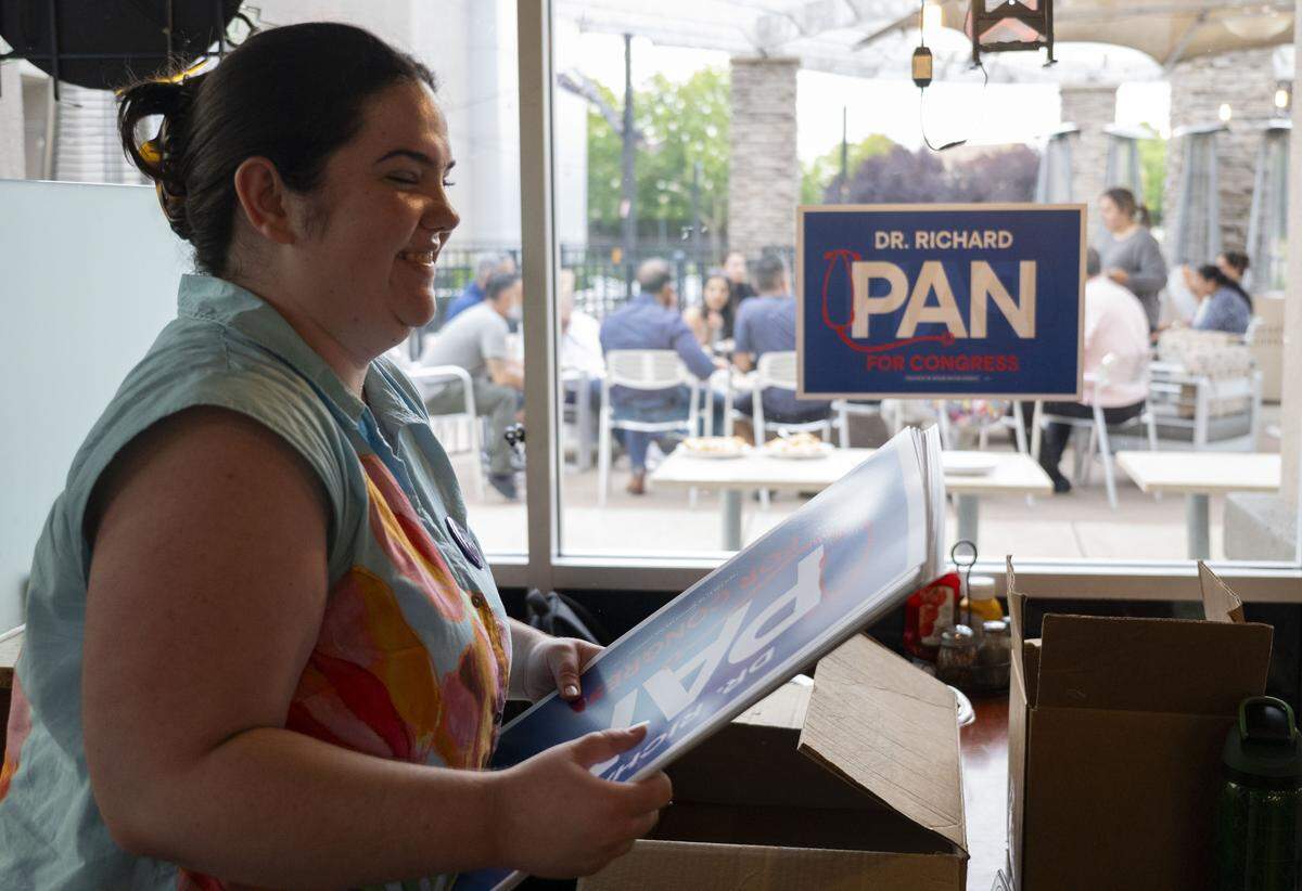 Belle Pearce, campaign finance director for former state Sen. Richard Pan, hangs up campaign signs ahead of Pan’s election night party at Frends Brewhouse in South Natomas on Tuesday. Pan is a candidate for the 6th Congressional District.