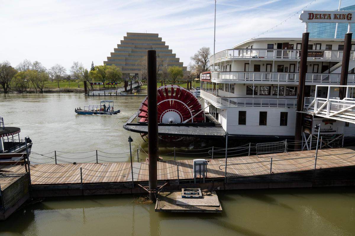A boat travels down the Sacramento River near the Delta King in Old Sacramento, Wednesday, April 5, 2023. Old Sacramento will get a hotel, waterfront viewing deck as part of state and city of Sacramento proposed revamp aimed at increasing visitors to the area.