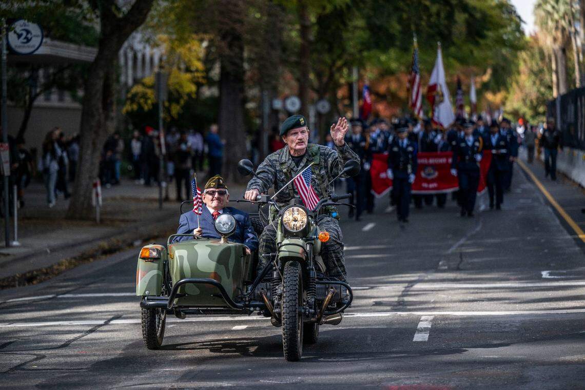 Robert Hipwell, an Army Veteranwaves to the crowd as he drives veteran Leroy John Adams during the Veteran’s Day Parade in Sacramento on Friday, Nov. 11, 2022.