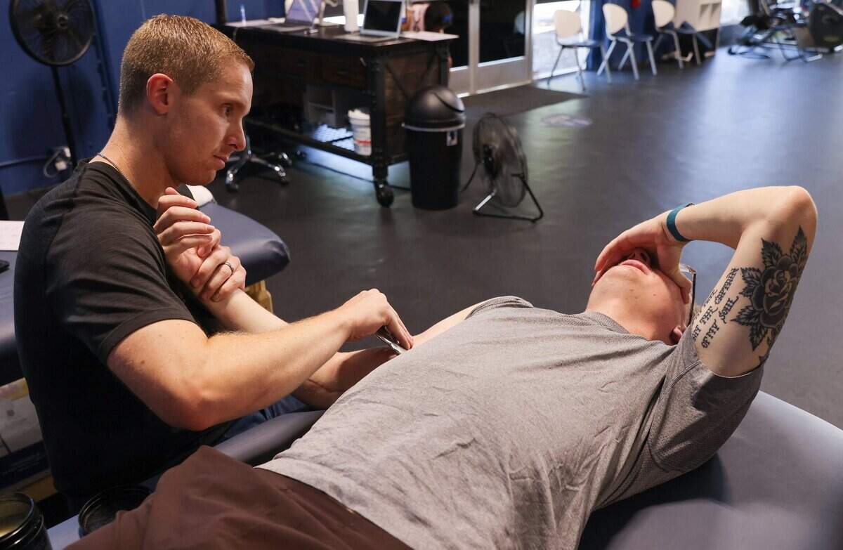 Physical therapist Evan Hauger massages Stone Churbys bicep at Kime Performance Physical Therapy in Sacramento on June 30. “Baseball world and professional organizations are very comfortable with this surgery and almost see it as close to an inevitable that a large percentage, if not most, of their pitchers are going to have this procedure at some point in time,” Hauger said. “What’s interesting is how good the outcomes have overall been with it and how comfortable professional organizations are with it.”