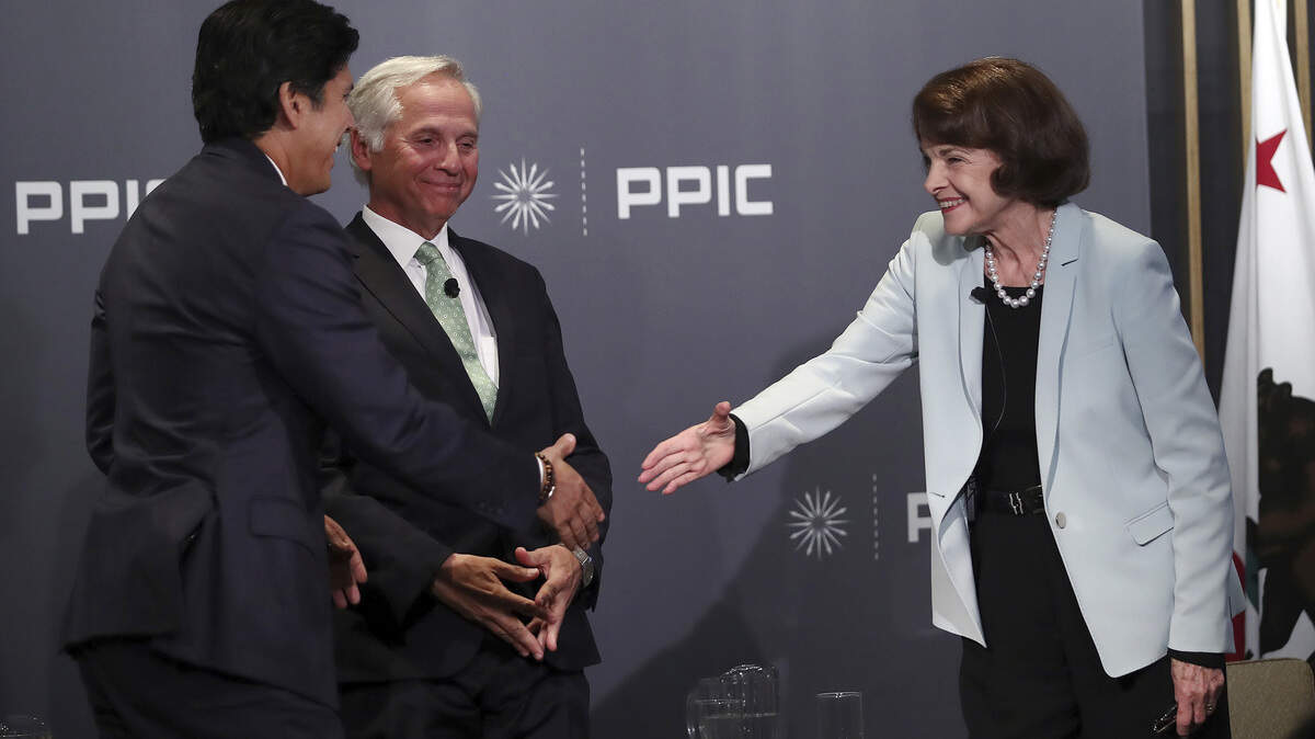 Sen. Dianne Feinstein reaches to shake the hand of state Sen. Kevin de Leon after a conversation Wednesday hosted by the Public Policy Institute of California.