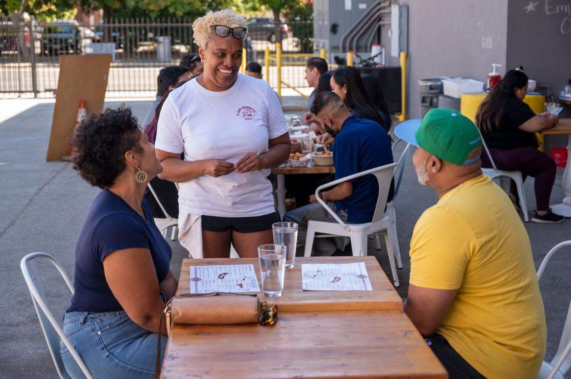 Jim-Denny’s owner N’Gina Guyton talks with customers Wednesday in the new spacious outdoor dining area.