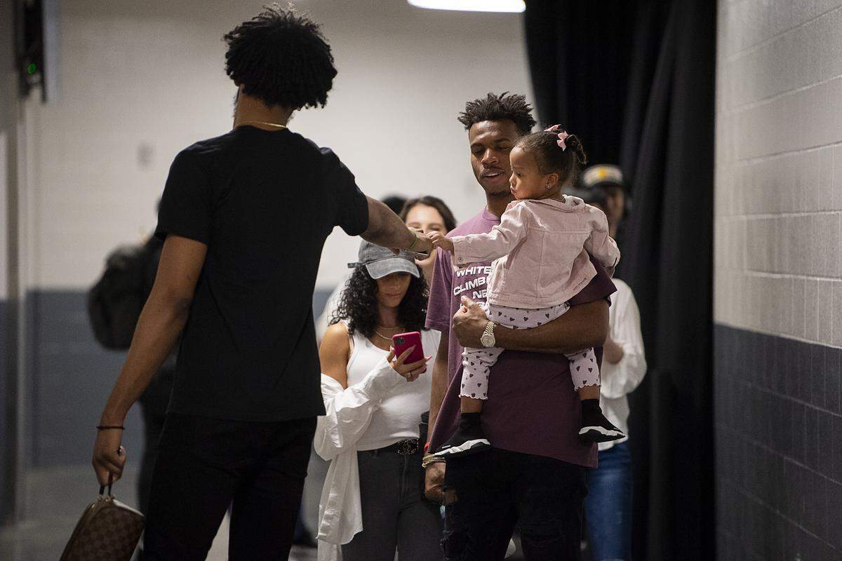 Sacramento Kings forward Marvin Bagley III (35) fist bumps Sacramento Kings guard Buddy Hield (24) and his daughter Rainer as they leave the Golden 1 Center on Wednesday, March 11, 2020 in Sacramento after the NBA suspends season after Jazz’s Rudy Gobert tested positive for coronavirus.