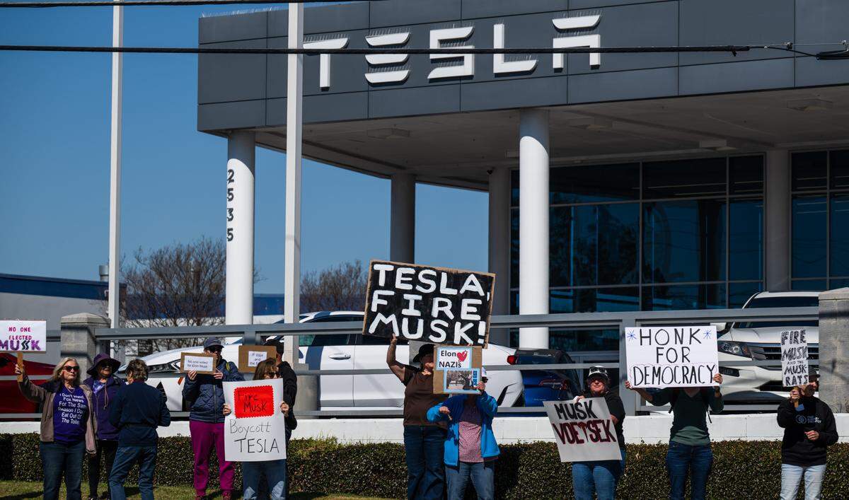 Demonstrators rally against Elon Musk at a Tesla dealership on Arden Way near Sacramento on Saturday, March 8, 2025. More than 100 people lined both sides of street to protest the role of the tech billionaire and Tesla CEO in the Trump administration.