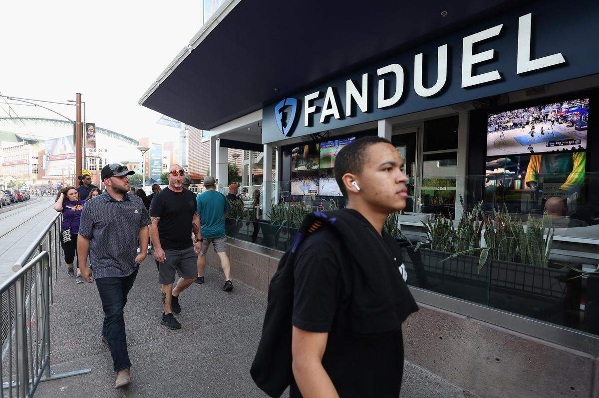 Fans walk past a Fanduel sports betting location at Footprint Center before Game Five of the Western Conference First Round NBA Playoffs between the Phoenix Suns and the New Orleans Pelicans in Phoenix in April.