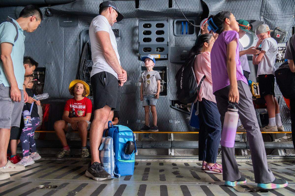 Joshua Hurst, center left, and 4-year-old Remington Hurst, center, wait in line to go up a ladder inside a Lockheed C-5 Galaxy during the California Capital Airshow at Mather Airport near Rancho Cordova on Saturday, July 13, 2024. Joshua Hurst said his son’s favorite part of the day had been running around inside the nearby UPS plane.