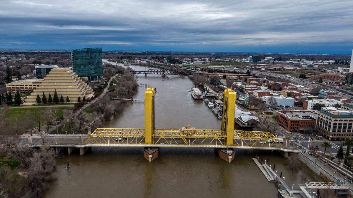 The swollen Sacramento River flows under the Tower Bridge during a pause in the rain on Monday, Feb. 3, 2025.