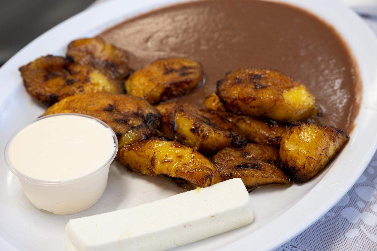 A plate of platanos ($4.99), or fried plantains, is served with a side of beans, Salvadorian sour cream and a piece of fresh cheese at Pupusas Central in Sacramento on Thursday.