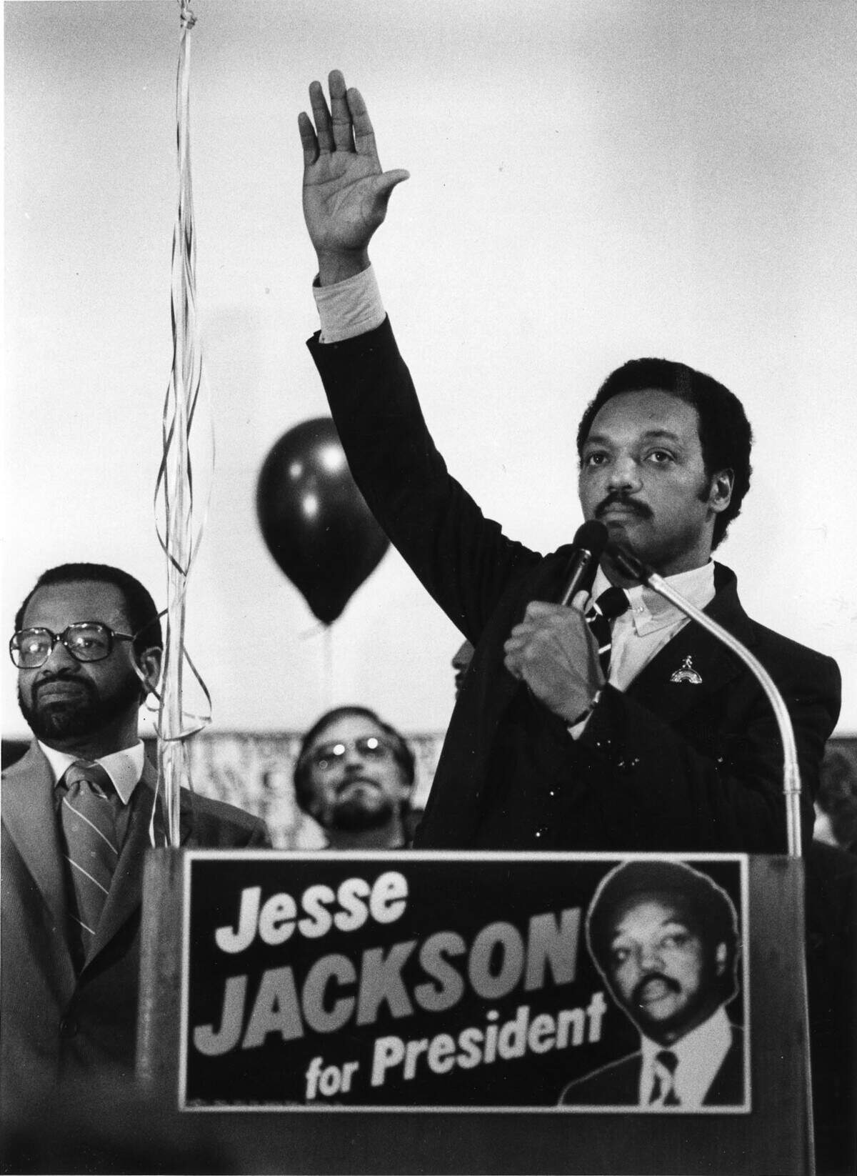 Rev. Jesse Jackson raises his hand to quiet the crowd as during a May 1984 rally at Laney College in Oakland.