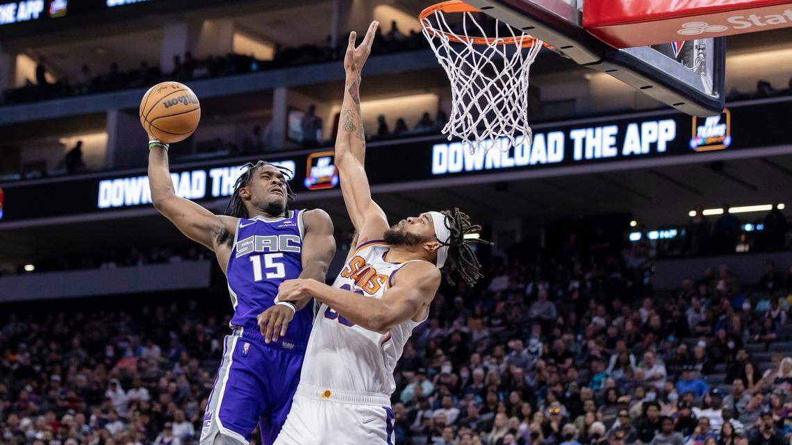 Sacramento Kings guard Davion Mitchell (15) goes up for a dunk with Phoenix Suns center JaVale McGee (00) defending and draws the foul with three seconds left in the third quarter on Sunday, March 20, 2022 during an NBA basketball game at the Golden 1 Center in Sacramento. Mitchell made both free throws and was the top scorer with 28 points and nine assists. The Suns win 127-124 in overtime.
