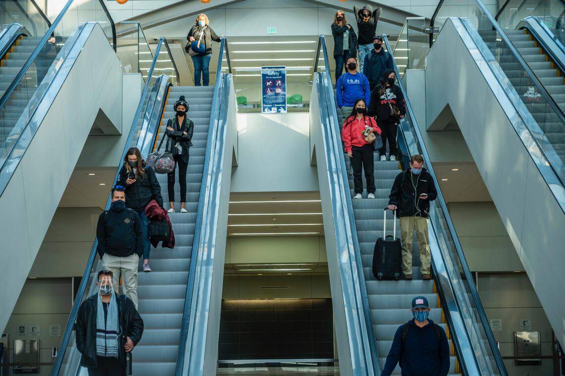Travelers come down the escalators in terminal B at the Sacramento International Airport on Monday, Nov. 23, 2020.