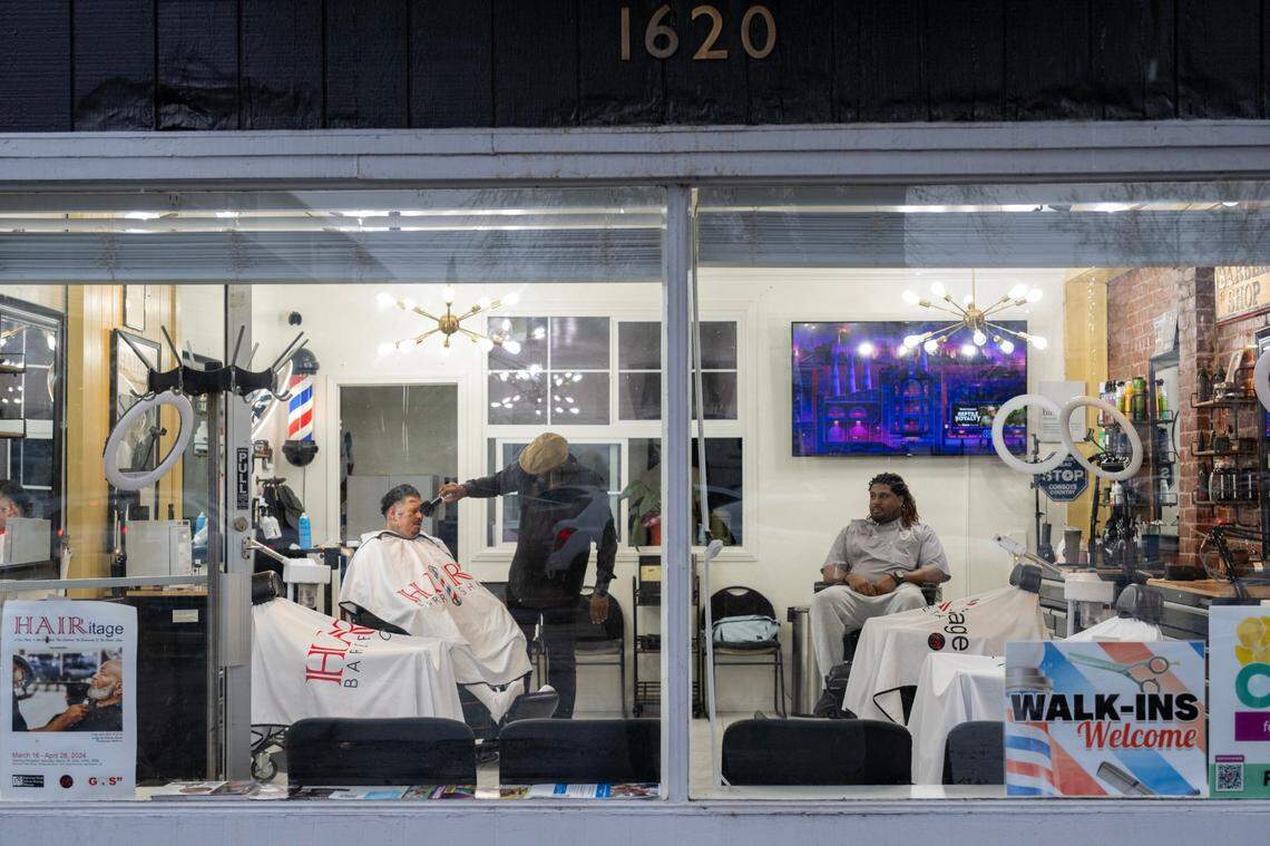 Marichal Brown finishes styling the hair of customer Joe Chavarria at HAIRitage Salon last month in Sacramento. Owners, brothers Marichal and Rodney Brown, are part of a growing national network of Black barbers and stylists who have become frontline mental health advocates for Black men, boys and their families.