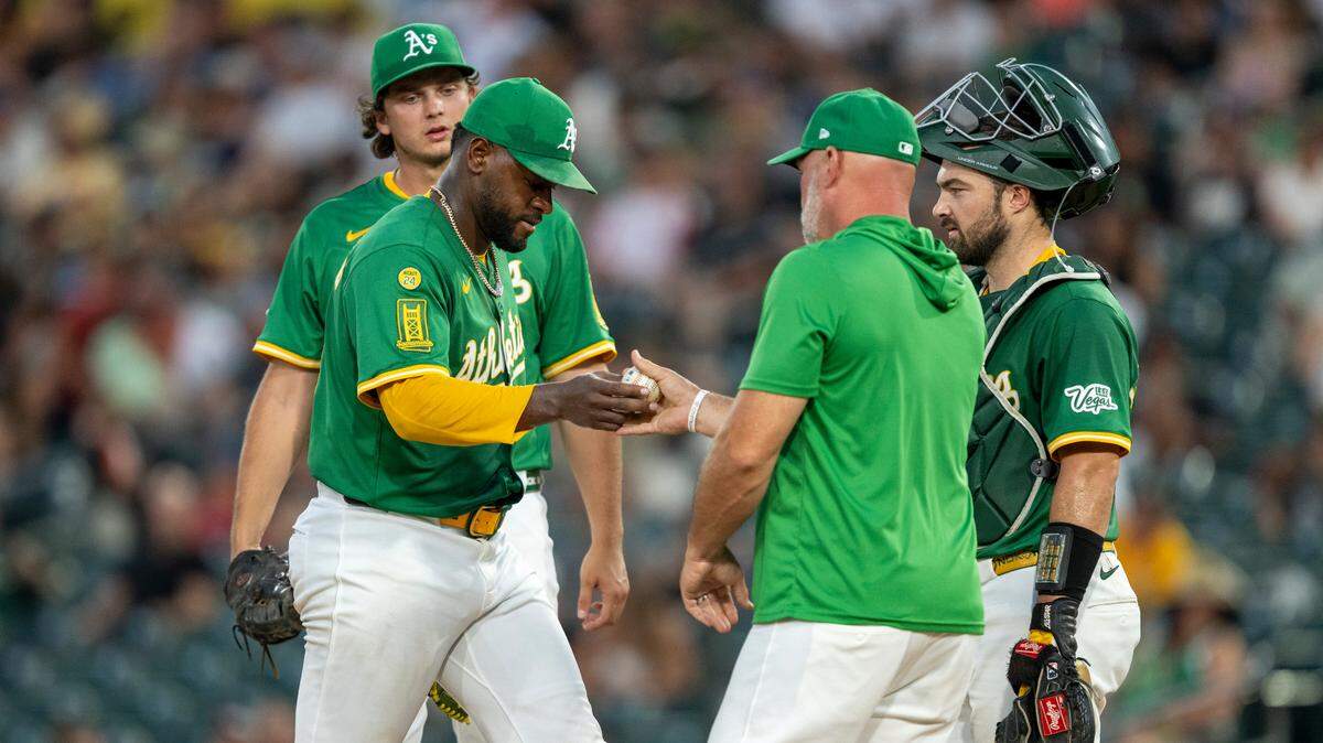 Athletics pitcher Luis Severino (40) hands the ball to manager Mark Kotsay (7) as a pitching change is made Friday during the fifth inning against the Toronto Blue Jays at Sutter Health Park.