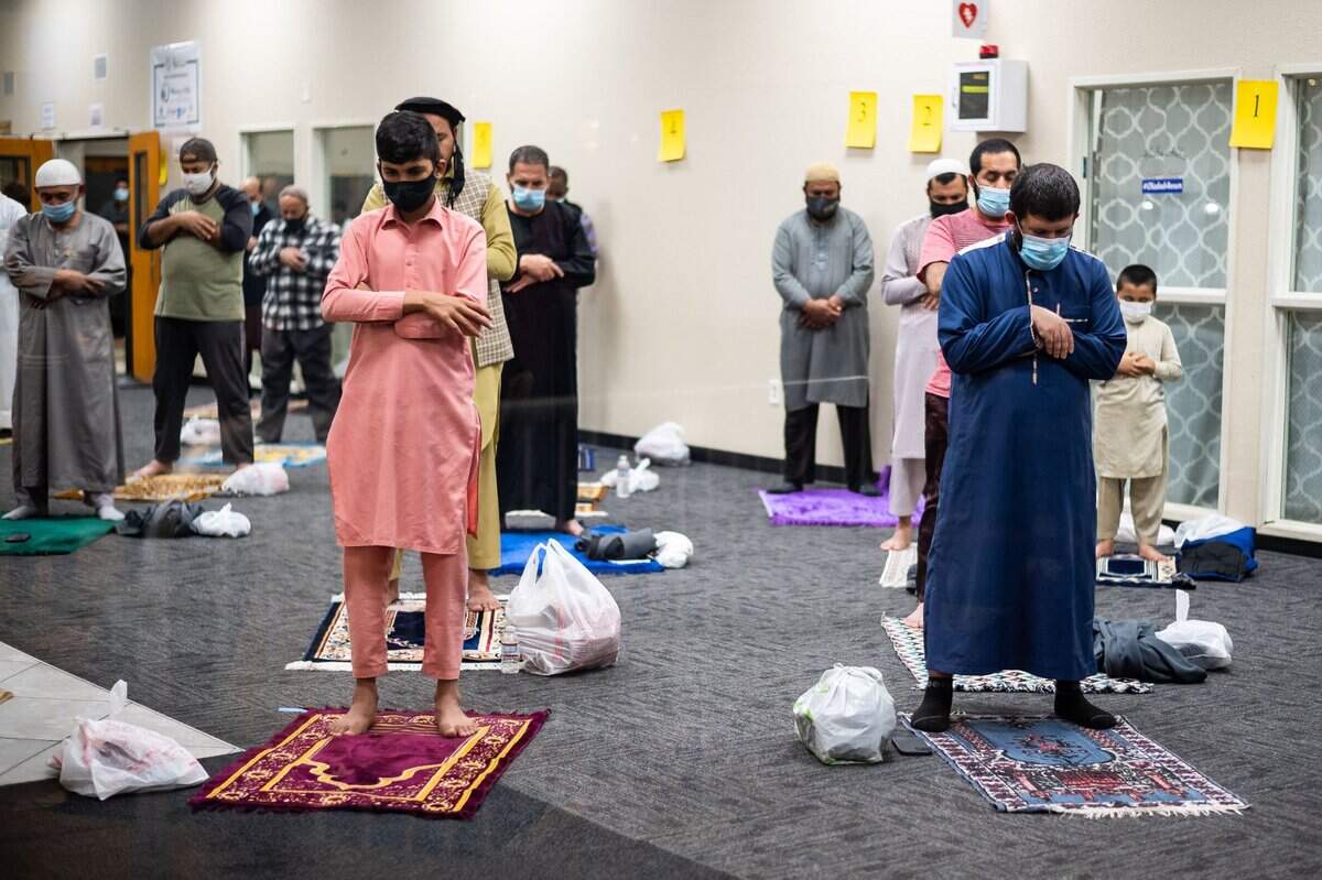 Worshippers wear masks and socially distanced inside south Sacramento’s Masjid Annur Islamic Center gather for Taraweeh prayers Tuesday. Around 400 people, spread out between indoors and outdoors, attended. Before the coronavirus, they would stand be should-to-shoulder in prayer.