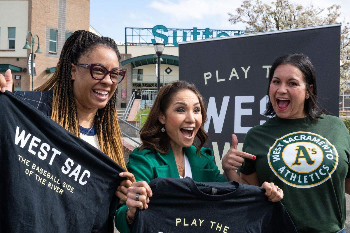 West Sacramento City council members Dawnté Early, left, Quirina Orozco, and Verna Sulpizio Hull show off their Athletics swag at Sutter Health Park after a press conference on March 27 to officially welcome the A’s to West Sacramento and celebrate the coming opening days for the city’s baseball teams.