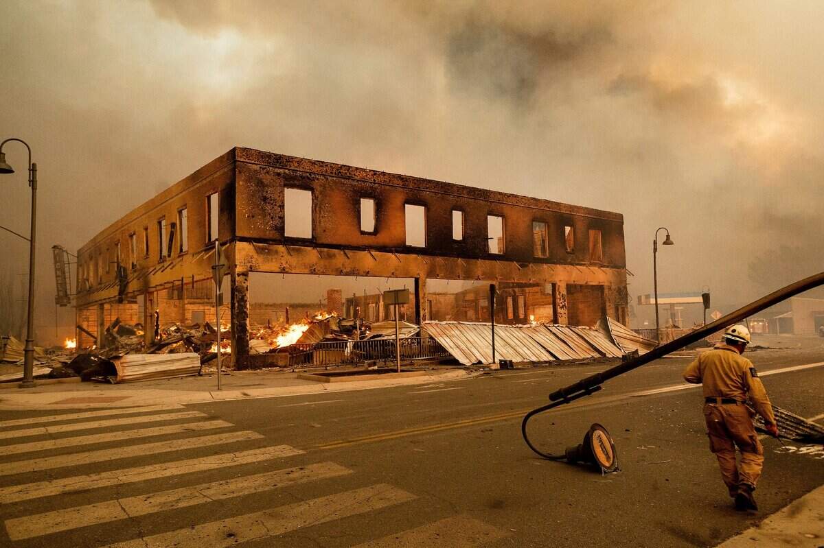 Operations Chief Jay Walter passes the historic Sierra Lodge as the Dixie Fire burns through the Greenville community of Plumas County, Calif., on Wednesday, Aug. 4, 2021. The fire leveled multiple historic buildings and dozens of homes in central Greenville. (AP Photo/Noah Berger)